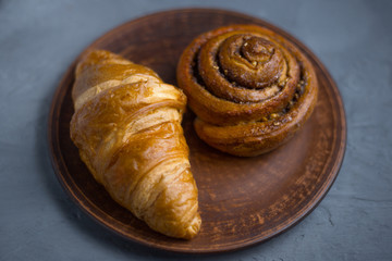 Fototapeta na wymiar Croissant and bun on plates