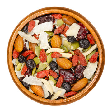 Superfood Snacking Mix In Wooden Bowl. Trail Mix Of Dried Almonds, Cranberries, Pepitas, Coconut Chips, Blueberries And Goji Berries. Closeup From Above On White Background, Isolated Macro Food Photo.