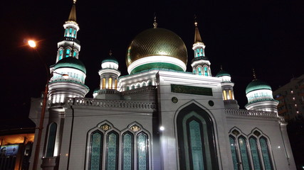 In the dark, the illuminated Cathedral is white with gold trim and an emerald pattern