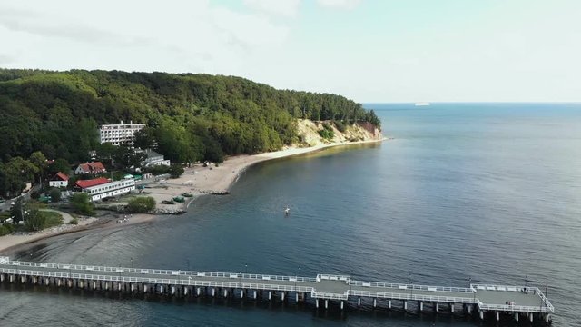 Widok na molo na zatoce z piaszczystą plażą i drzewami z lotu ptaka