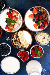 Tasty homemade granola served on table. Healthy breakfast with a bowl of oatmeal with banana, blueberries, strawberries and healthy food for Breakfast
