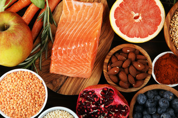 Healthy food clean eating selection: fish, fruit, vegetable, cereal, leaf vegetable on rustic background