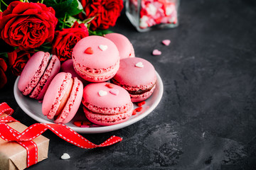 Valentijnsdag roze cake macarons met rode rozen, geschenkdoos en rode harten
