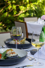 Beautifully decorated meals and a glasses of wine on the wooden table