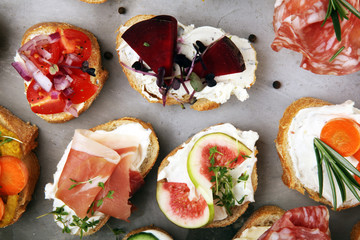 Assorted bruschetta with various toppings. Appetizing bruschetta or brie crostini. Variety of small sandwiches. Mix bruschetta on table