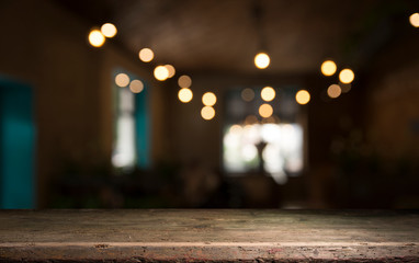 Empty wood table top on blur light gold bokeh of cafe restaurant in dark background
