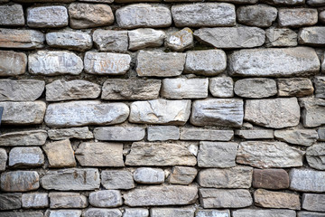 Abstract masonry wall surface of gray textured stones