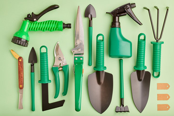 Gardening tools on green background flat lay