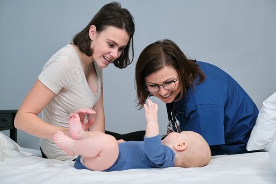 Visit Of Pediatrician To Mom And Baby Home. Talking Doctor And Young Mother