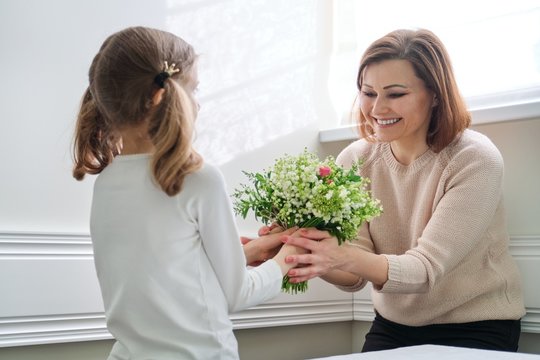 Daughter congratulating mom on beautiful spring flowers on mothers day