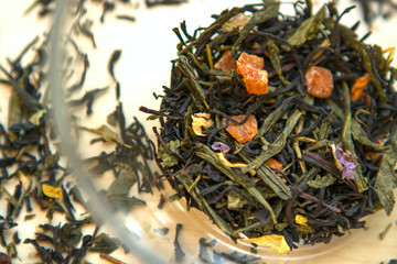dry tea mix with herbs and fruit slices in a transparent cup, bowl, mug