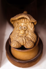figure of an old man in bast shoes made of ceramics