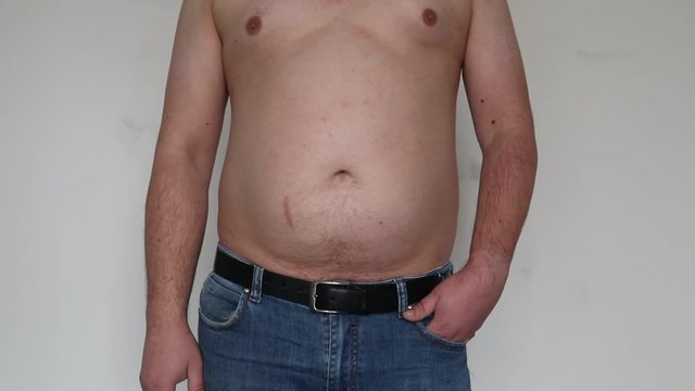 man shakes creases on his stomach. Close-up. On white background.