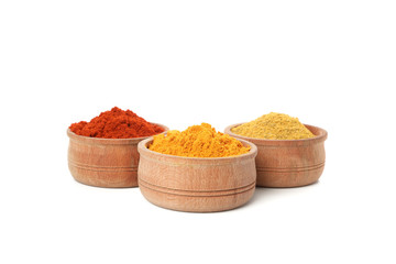 Wooden bowls with red pepper, curry and turmeric powder isolated on white background