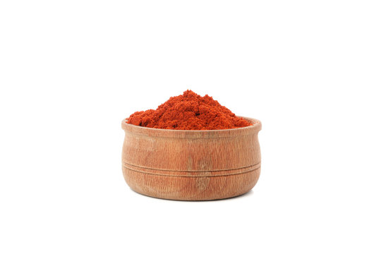 Wooden bowl with red pepper powder isolated on white