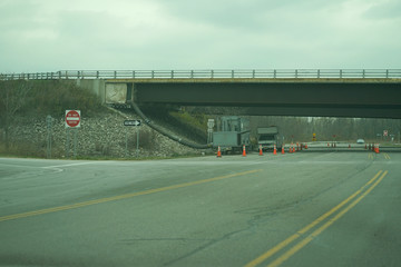 Cars standing under bridge on the highway.