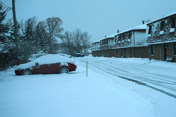 Snowy street with snow covered cars.