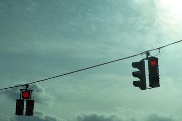 Traffic lights hanging on wires in the air.