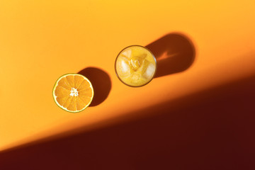 Orange fruit and cold orange juice in sunlight. Summer drink