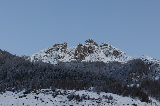 Piz tomuel or wissensteinhorn mountain and forest covered with snow seen from vals in switzerland.