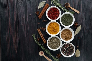 The view from the top. Indian cuisine. Condiment. Seasonings with fresh and dried herbs in bowls on an old wooden background. Free space for copying