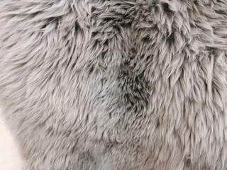 Fur rug, the surface of the sheepskin. Gray fur with a long NAP. A feeling of warmth and softness.