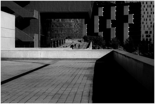 Facha y patio modernista en blanco y negro con torre Agbar al fondo entre dos edificios.
