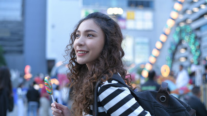 Holiday concept. Beautiful girls are eating lollipops happily in the amusement park. 4k Resolution.