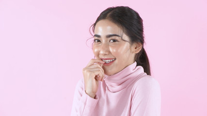 Beauty concept. Beautiful girl is lollipop when knowing jokes on a pink background. 4k Resolution.