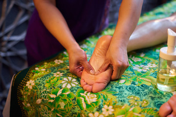 Thai massage, a girl is given a foot massage, foot massage with oil