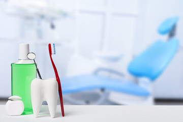 Dental health and teethcare concept. Dental mirror in white tooth model near mouthwash, toothbrush...