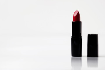 Obraz premium Red lipstick on white background, reflection, copy space