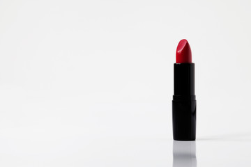 Red lipstick on white background, reflection, copy space