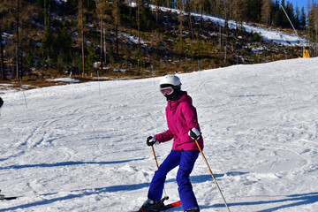 Girl learning to ski on the snow on the hill