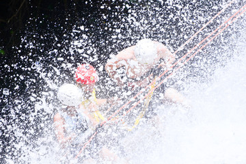 rappelling at a waterfall in the woods