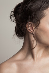 young woman part of face and wet hair in bun close up natural beauty concept studio shot