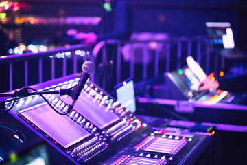 Audio sound mixer console with buttons, sliders and microphone at the concert. Selective focus