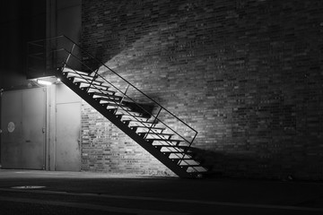 illuminated metal stair at night, simple stairway at night, black and white photo, sepia