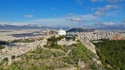 Aerial drone photo of iconic chapel of Saint George on top of Lycabettus hill with beautiful deep blue sky and clouds, Athens, Attica, Greece