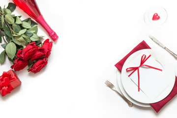 Romantic table setting with bouquet of red roses and gift. View from above. Valentine day.
