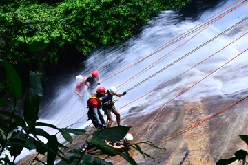 Abwaschbare Fototapete rappelling at a waterfall in the woods, world water day, extreme sport safely, Bonito, Pernambuco, Brazil, abseiling in the Bonito waterfall, adventure sport, tourism in brazil © liligluck