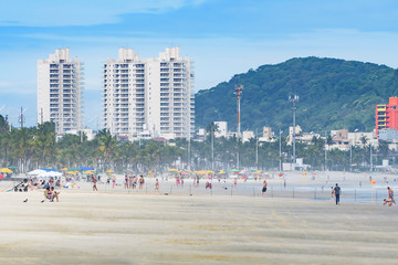 People on the beach on a sunny day, Brazilian tourist destination. View of Praia da Enseada -...
