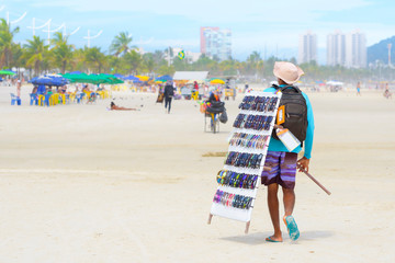 Street vendor selling sunglasses at a brazilian beach. 