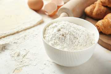 Fototapeta na wymiar Bowl with flour on table