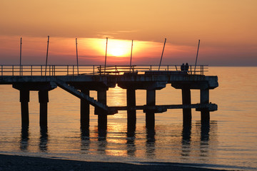 Sea pier in the sea at sunset