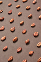 Organic cocoa beans pattern on a brown background.