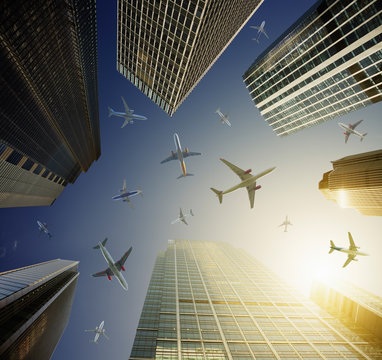 Airplanes in blue sky above highrise buildings, travel concept