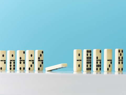 Domino falling in a row on blue background