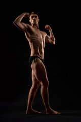Fototapeta na wymiar Male bodybuilder demonstrating contest pose.