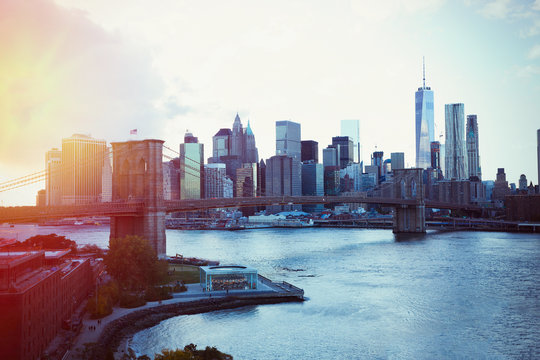 Cityscape view of New York and Brooklyn Bridge at sunset